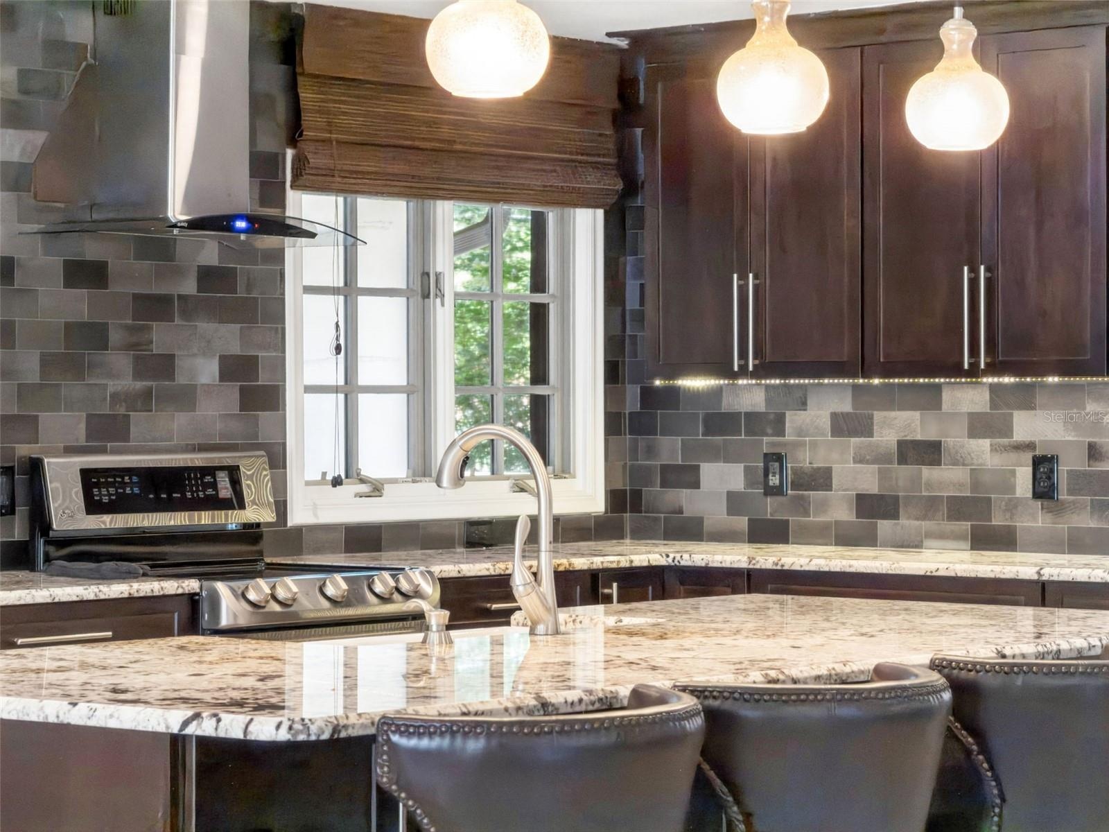 Under cabinet lighting, Stainless exhaust and Natural light enhance the kitchen.