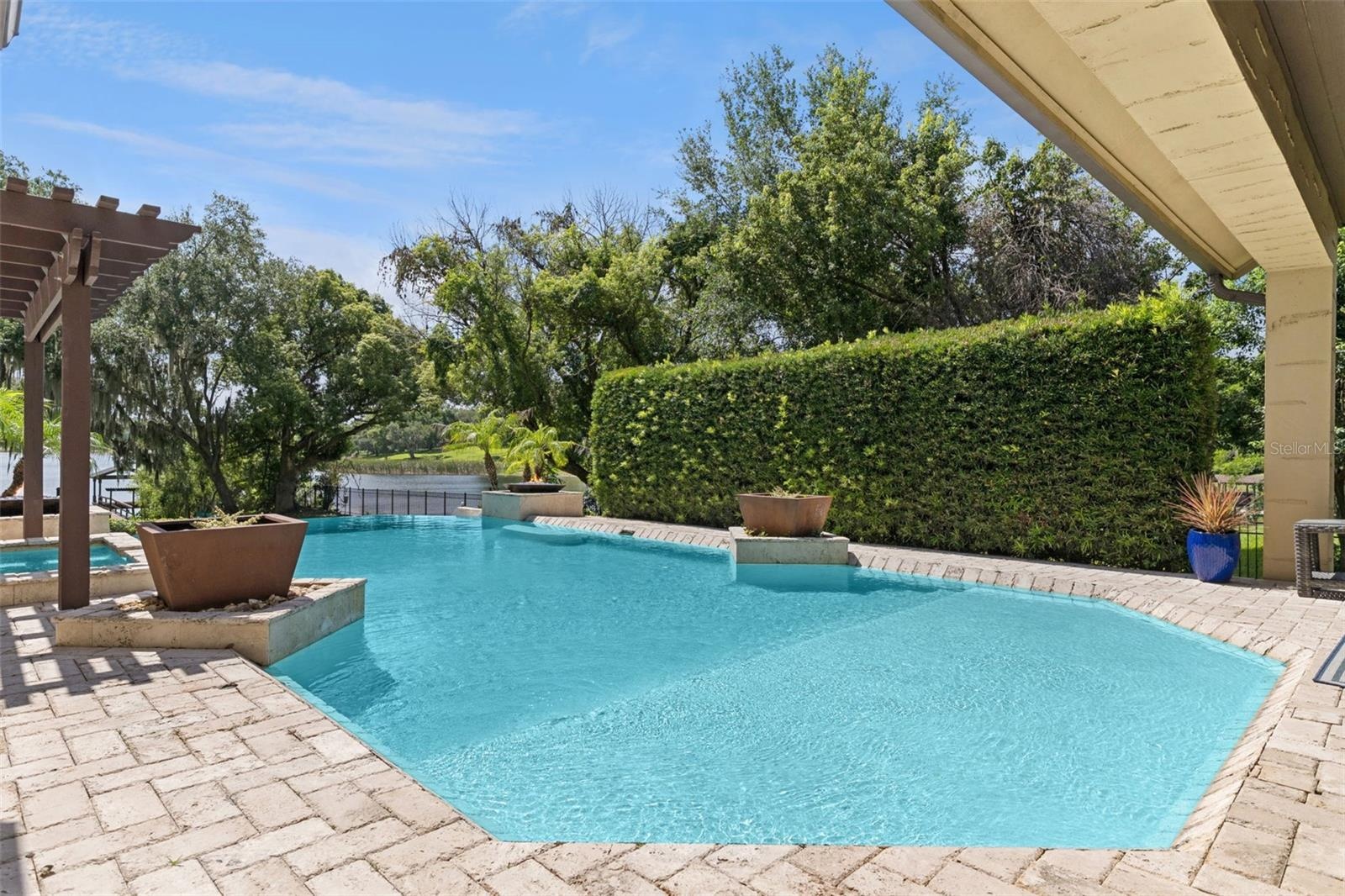 Large hedge provides privacy.  Pool has baja shelf for that tanning in the water