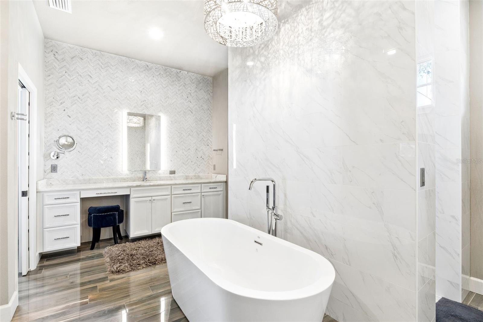Marble Walls and Ceiling to Counter glass tiled backspace, backglowing mirrors and attached hanging magnifying  mirror.