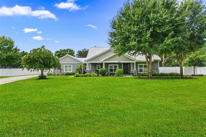 Stunning custom contemporary estate situated on over an acre, featuring exceptional curb appeal, a 30-year Galvalume metal roof, lush landscaping, and