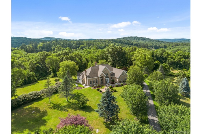 A private country estate awaits, beautifully sited on over 22 acres of rolling lawns, mature trees, and scenic beauty.