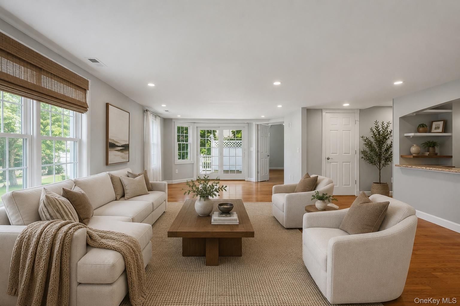 Spacious family room area featuring wood-finish flooring, recessed lighting, and a neutral color palette