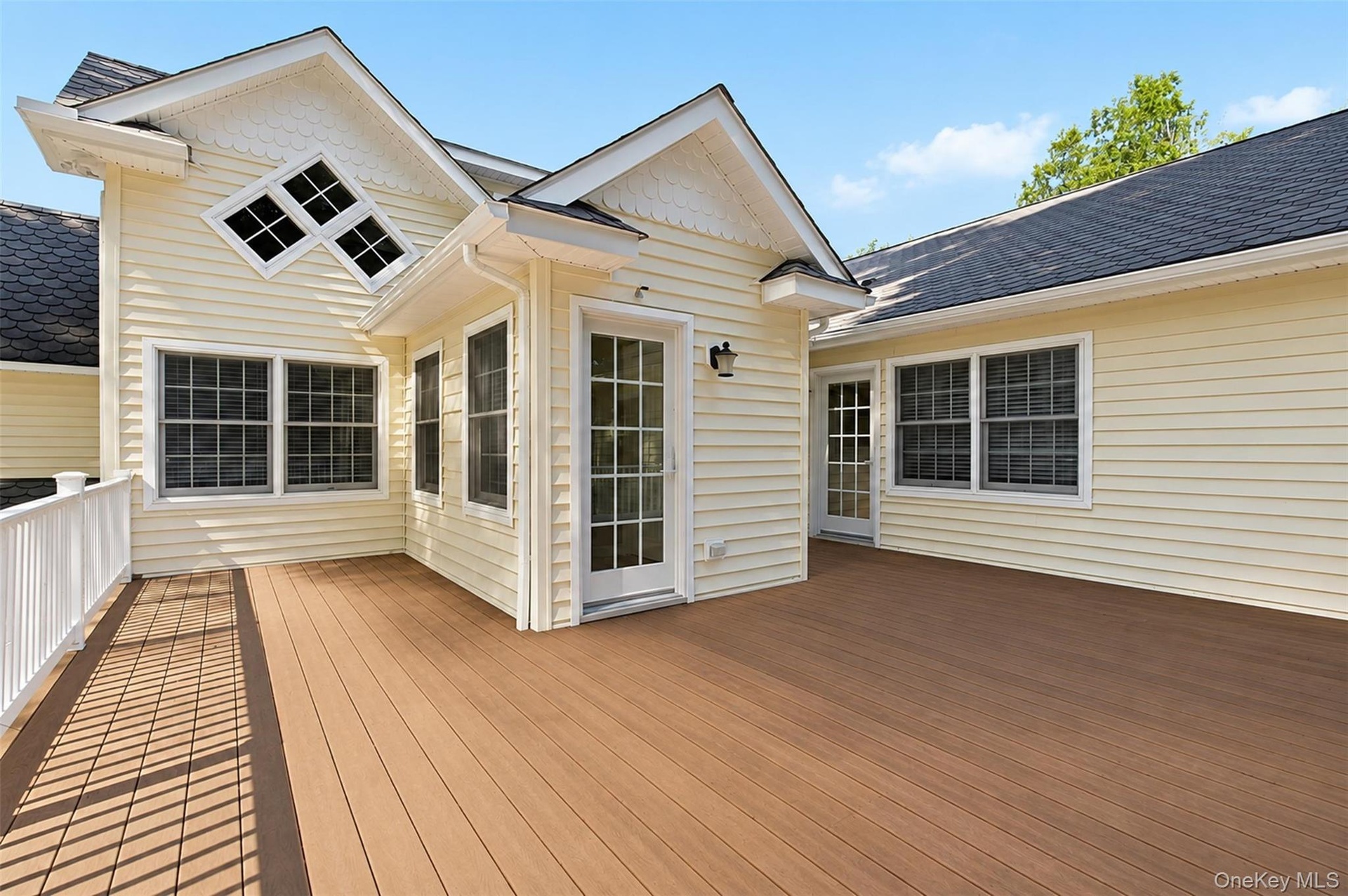 Expansive outdoor deck featuring wood-finish flooring and white railing