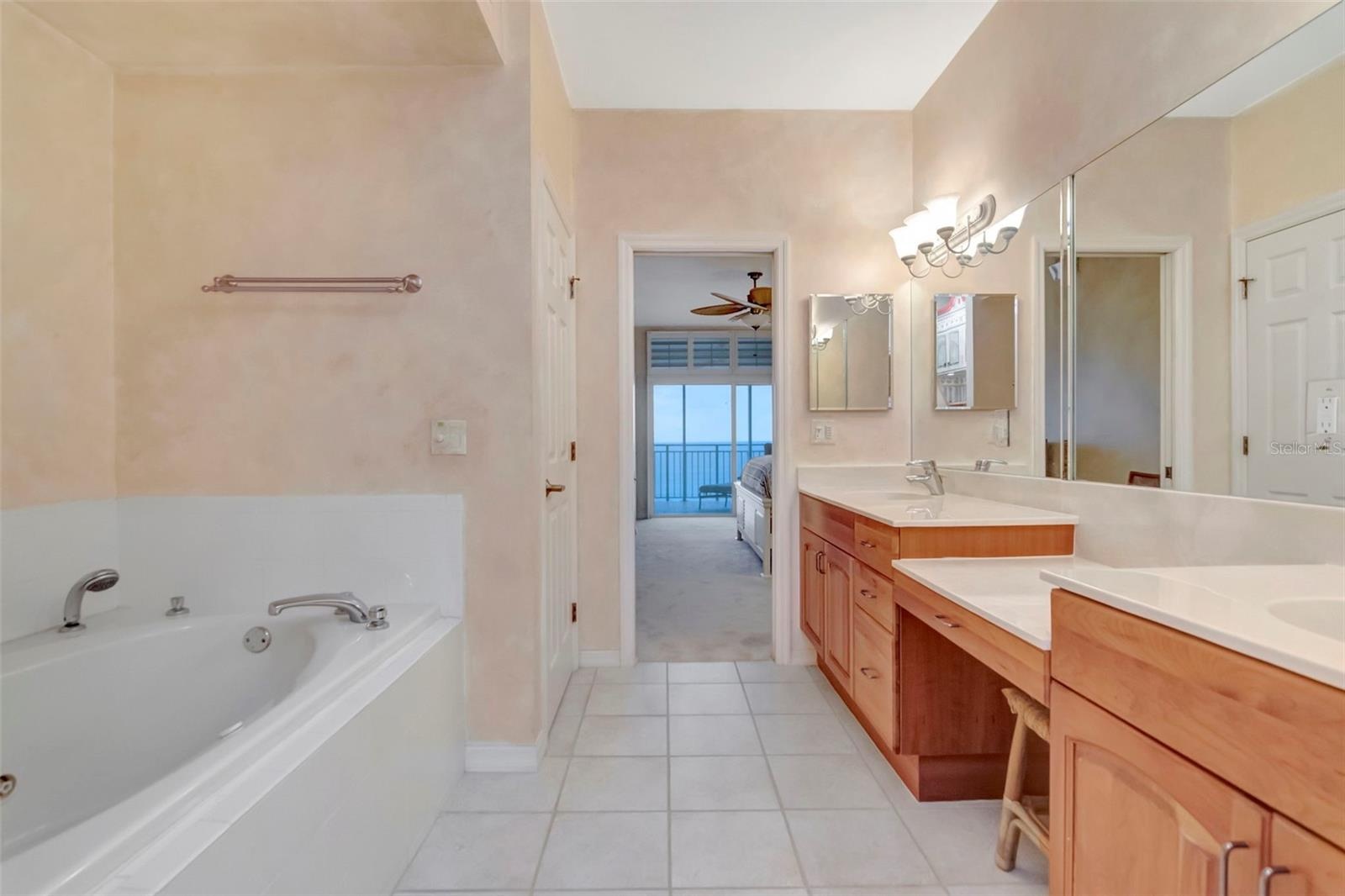 Primary bedroom ensuite with double vanity sinks, whirlpool bath, separate shower and toilet.