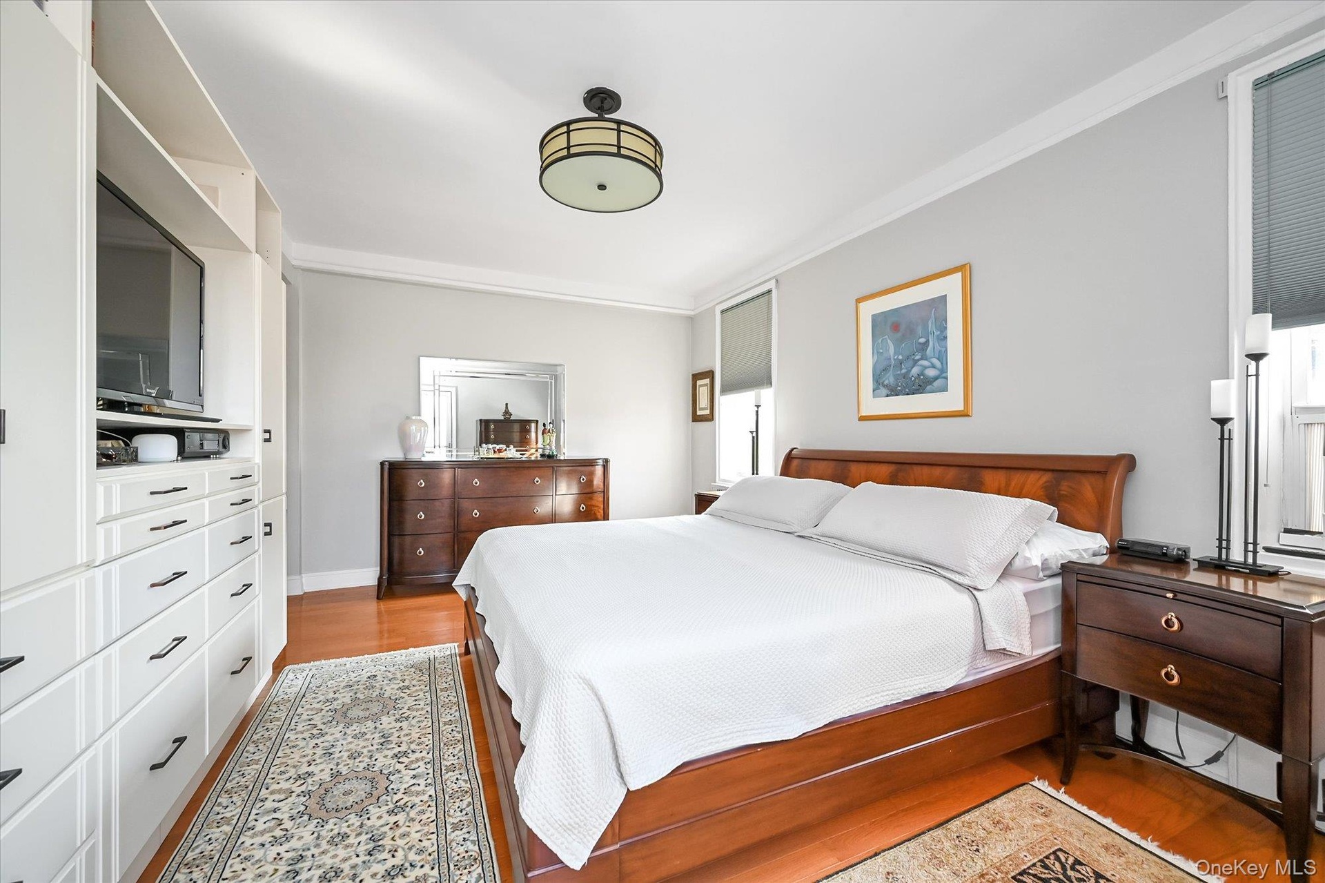 The king-size primary bedroom features custom built in cabinetry for substantial added storage, and a large private decked balcony with open views tow
