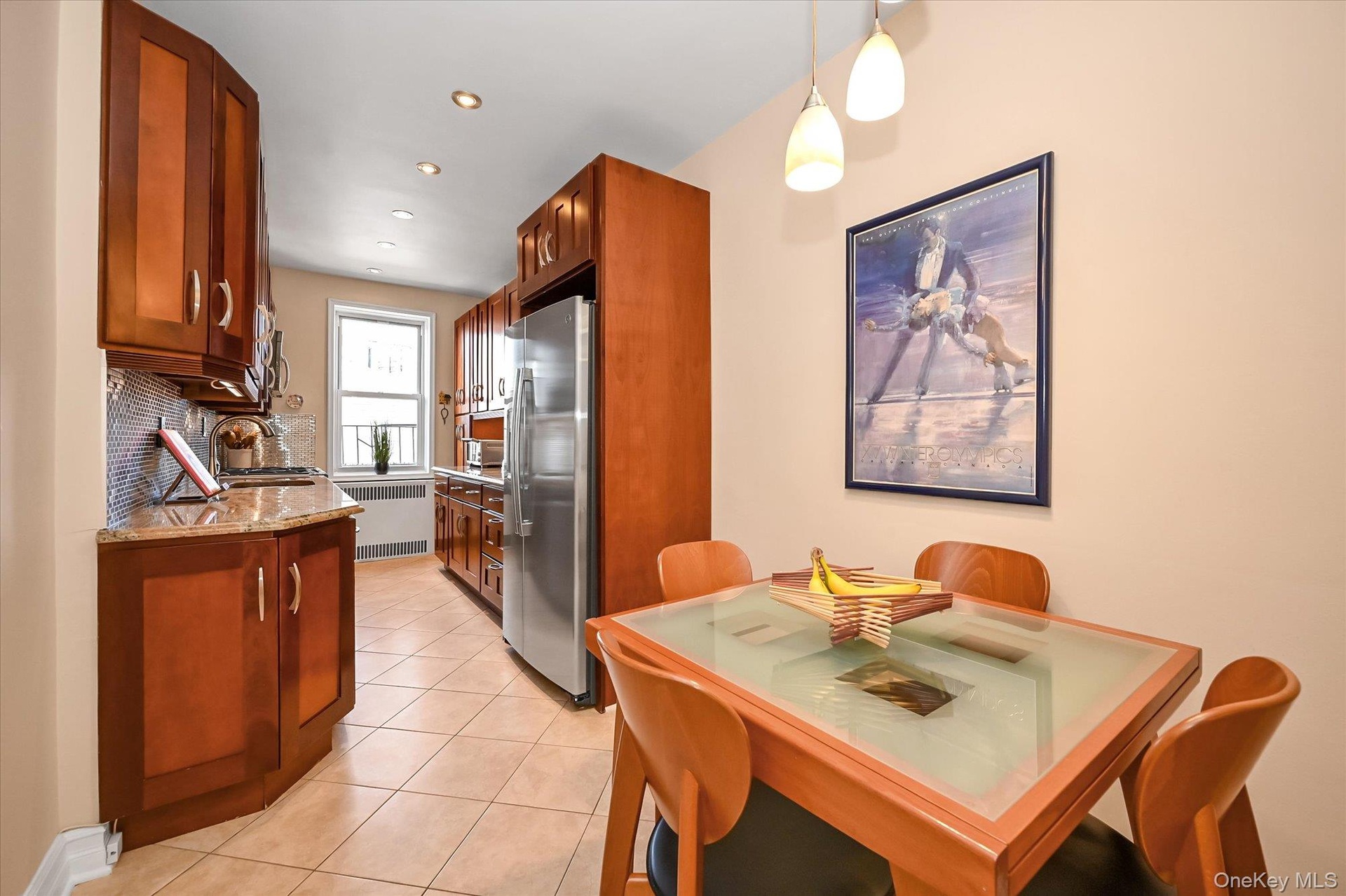Eat in chef’s kitchen includes wood cabinetry with soft close doors, a dedicated pantry, granite countertops, stone tile flooring, and top of the line