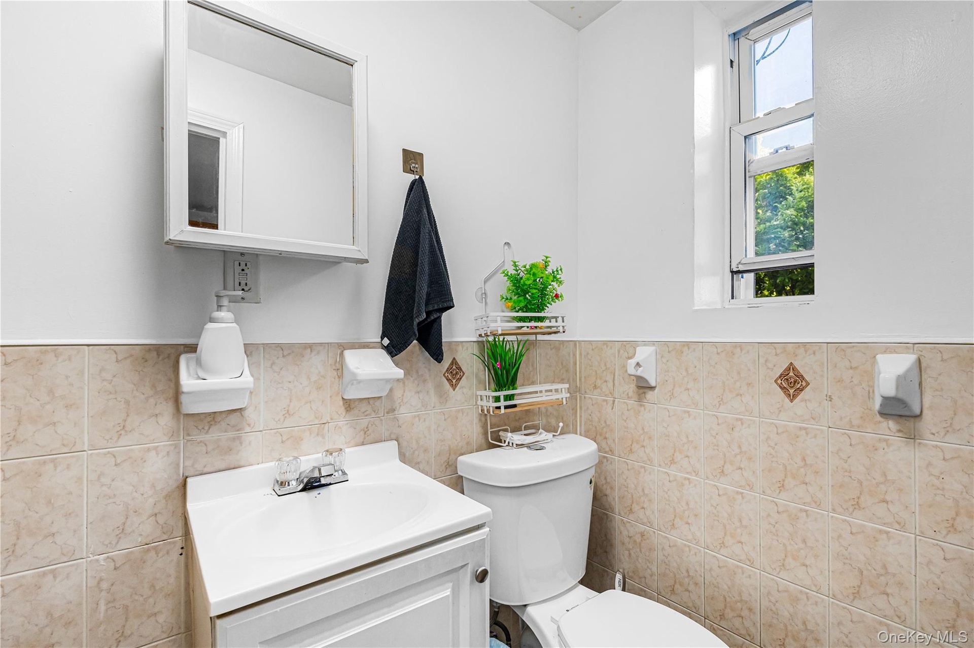 Bathroom featuring a single vanity, tiled walls, and an overhead medicine cabinet
