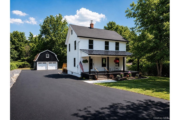 Classic white residence with a dark metal roof and front porch
