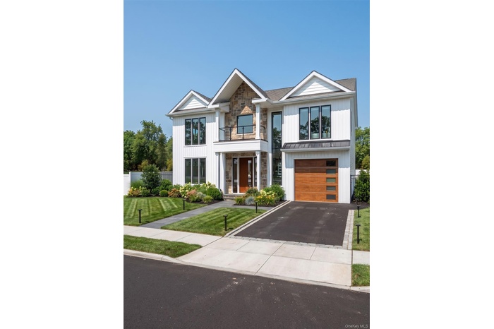Contemporary residential exterior featuring white vertical siding and stone accents