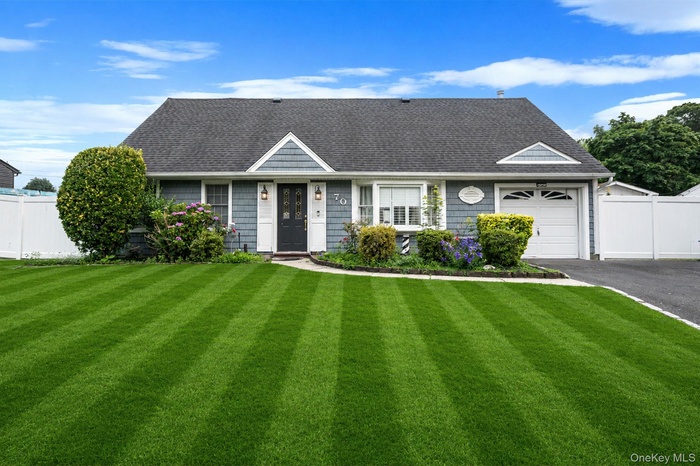 Cape Cod residence featuring blue siding, white trim, a dark asphalt shingle roof, a single garage, and a paved driveway