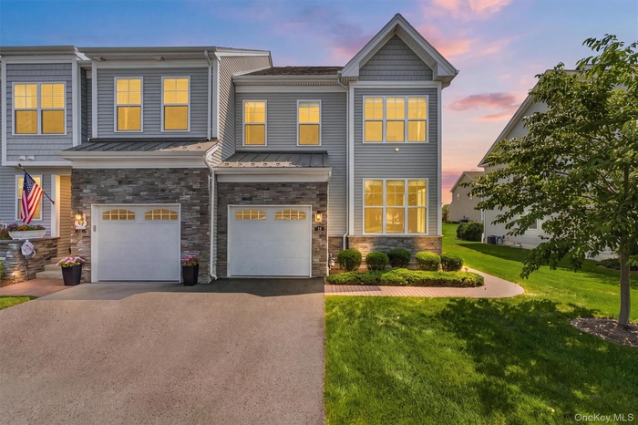 Contemporary townhome exterior featuring light gray siding and stone accents