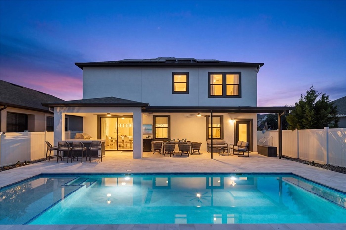 Stunning twilight view of the heated saltwater pool and resort-style outdoor living area