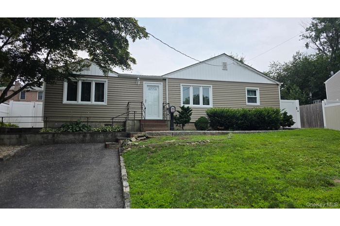 Exterior featuring tan horizontal siding, white trim, and a white entry door