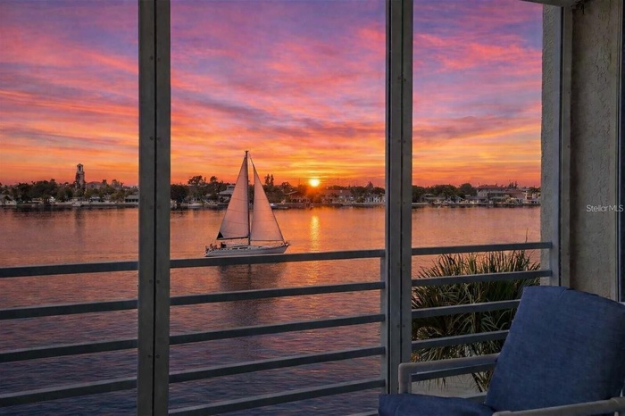 SUNSET BALCONY • IMPACT WINDOWS. A west-facing balcony captures glowing evening skies over the Intracoastal, enhanced by new gemstone floor coverings 