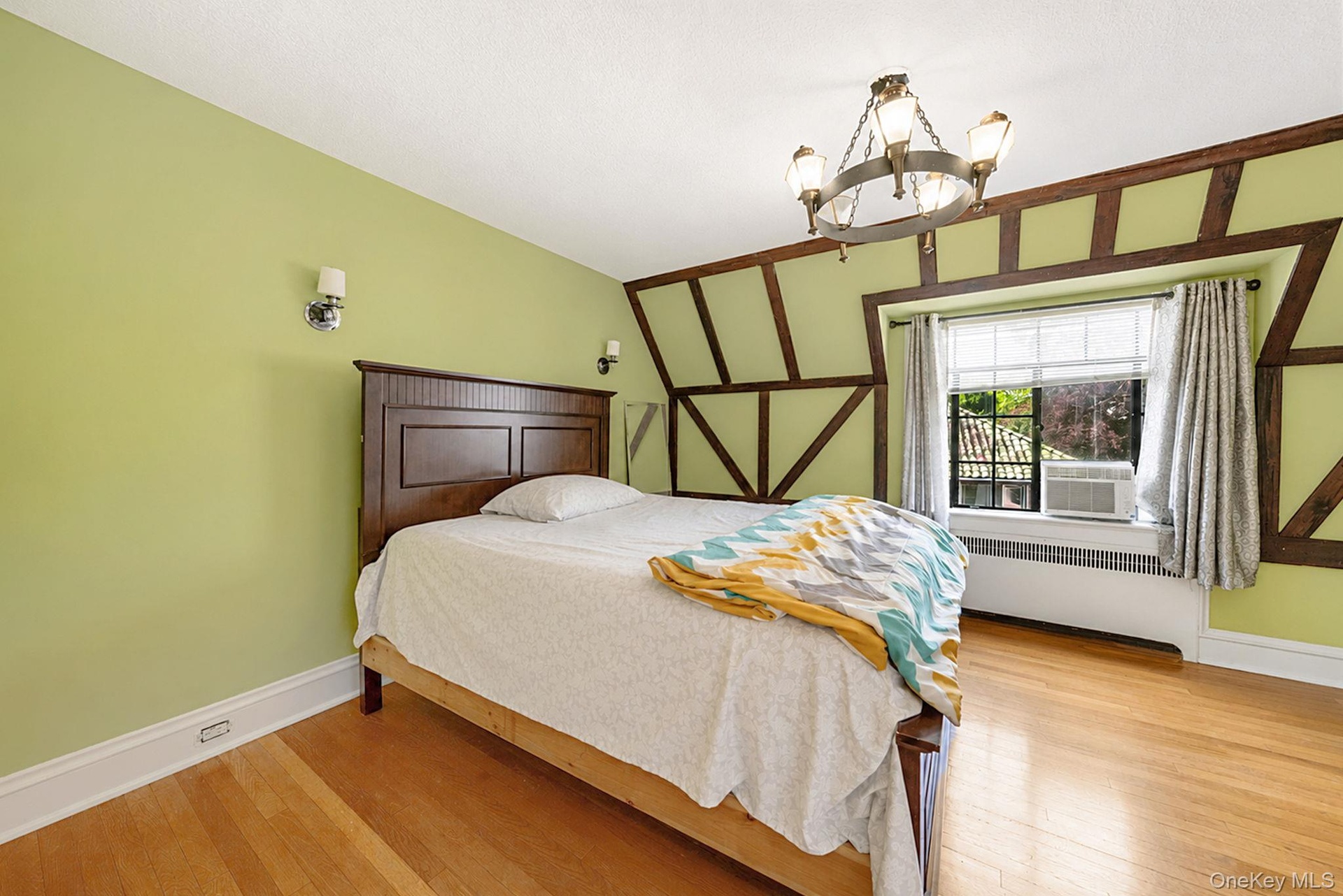 Bedroom featuring exposed timber framing and light wood-finish flooring
