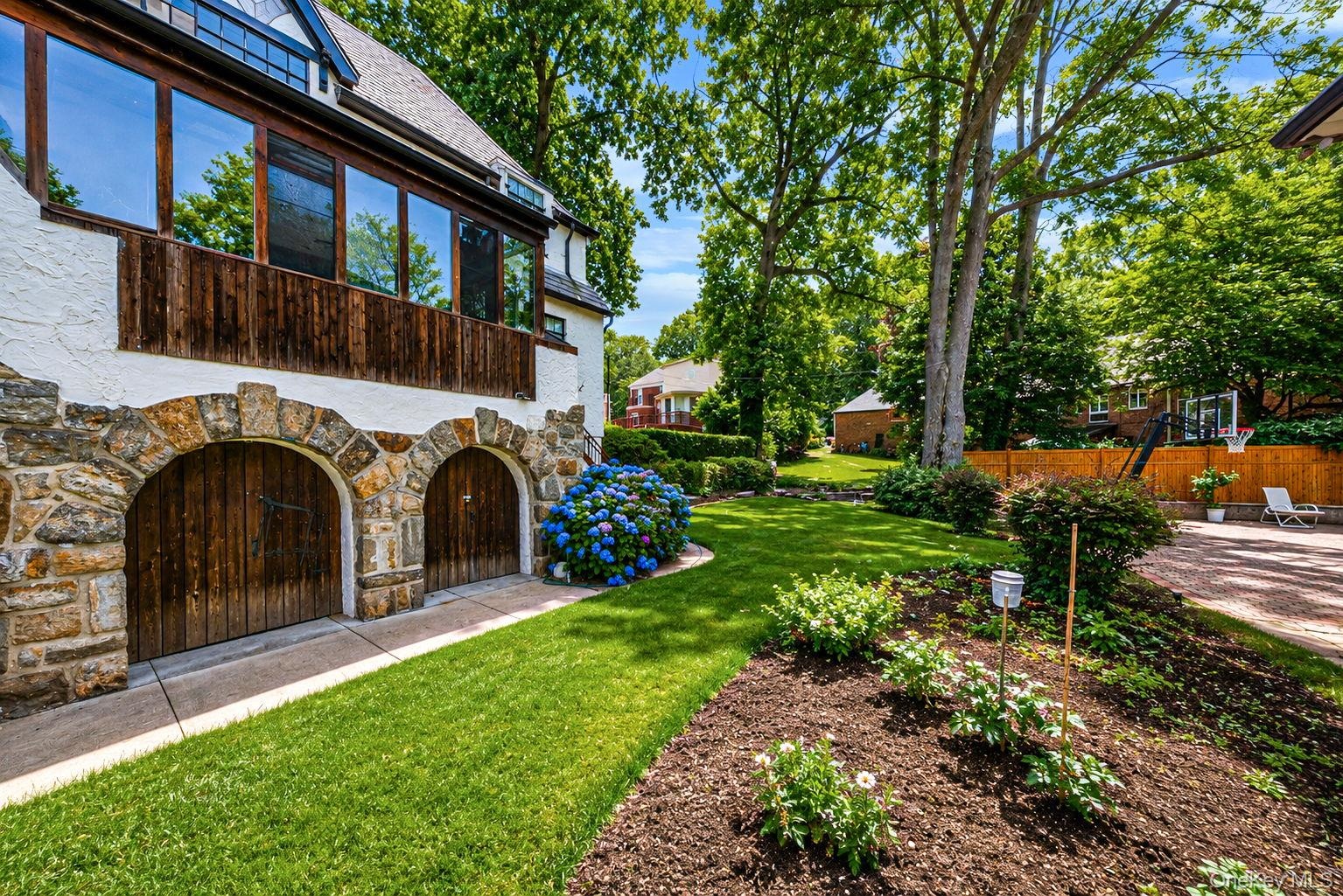 Stone-clad arched garage doors with wood paneling