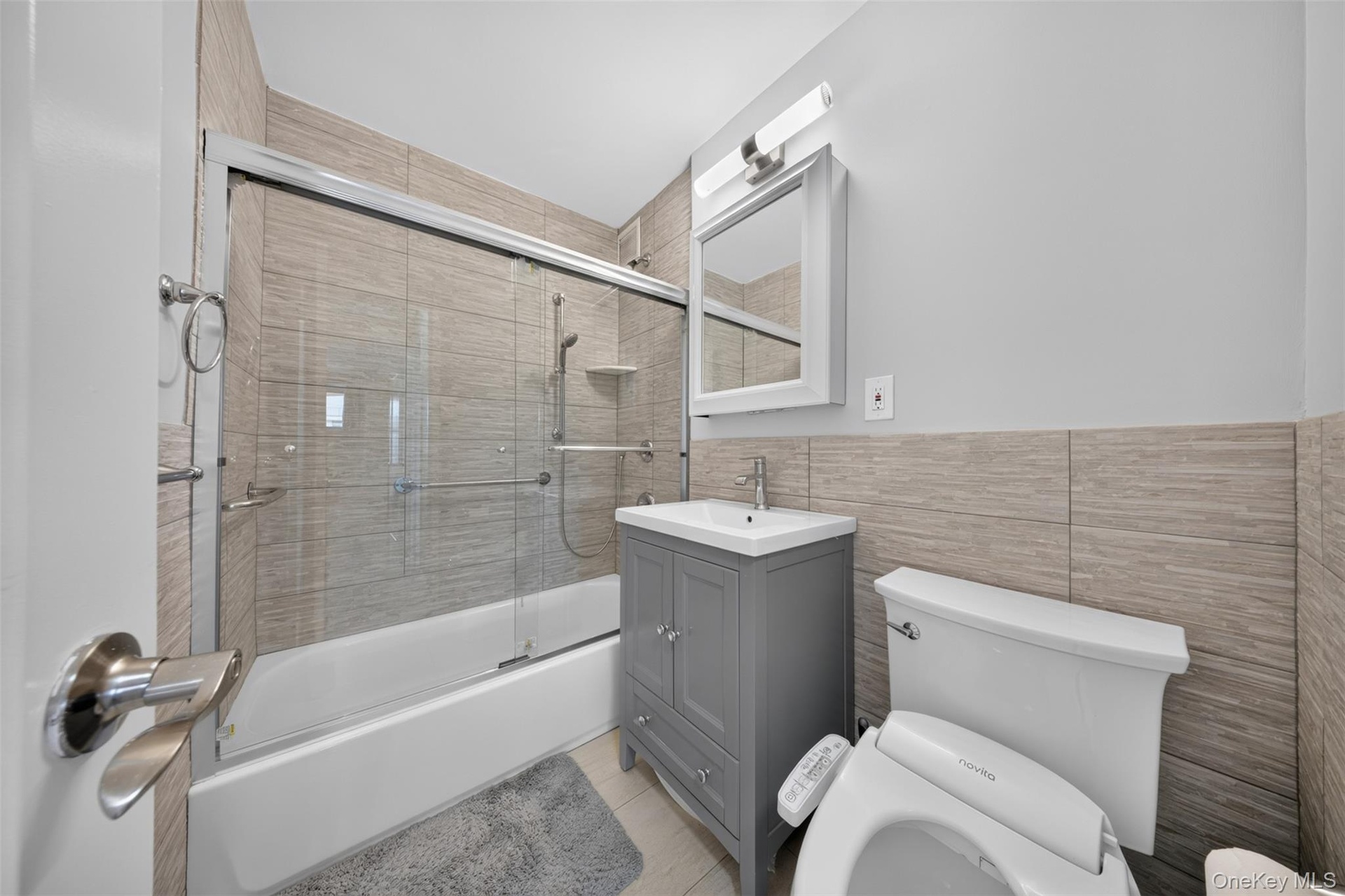 Full bathroom with tub/shower combination, vanity storage, and bidet
