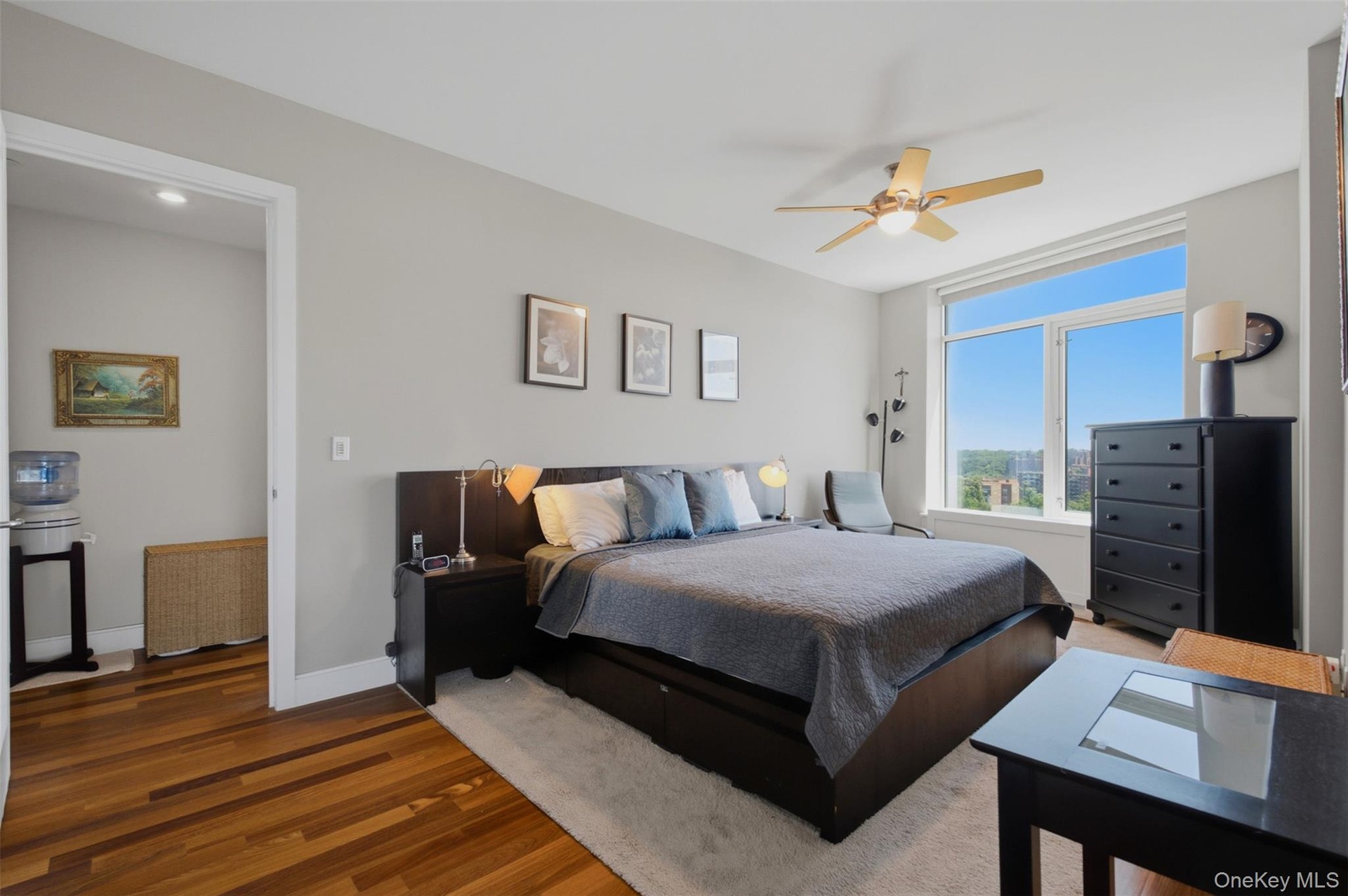 Bedroom 2 with expansive windows illuminate the room, complemented by a ceiling fan with integrated lighting