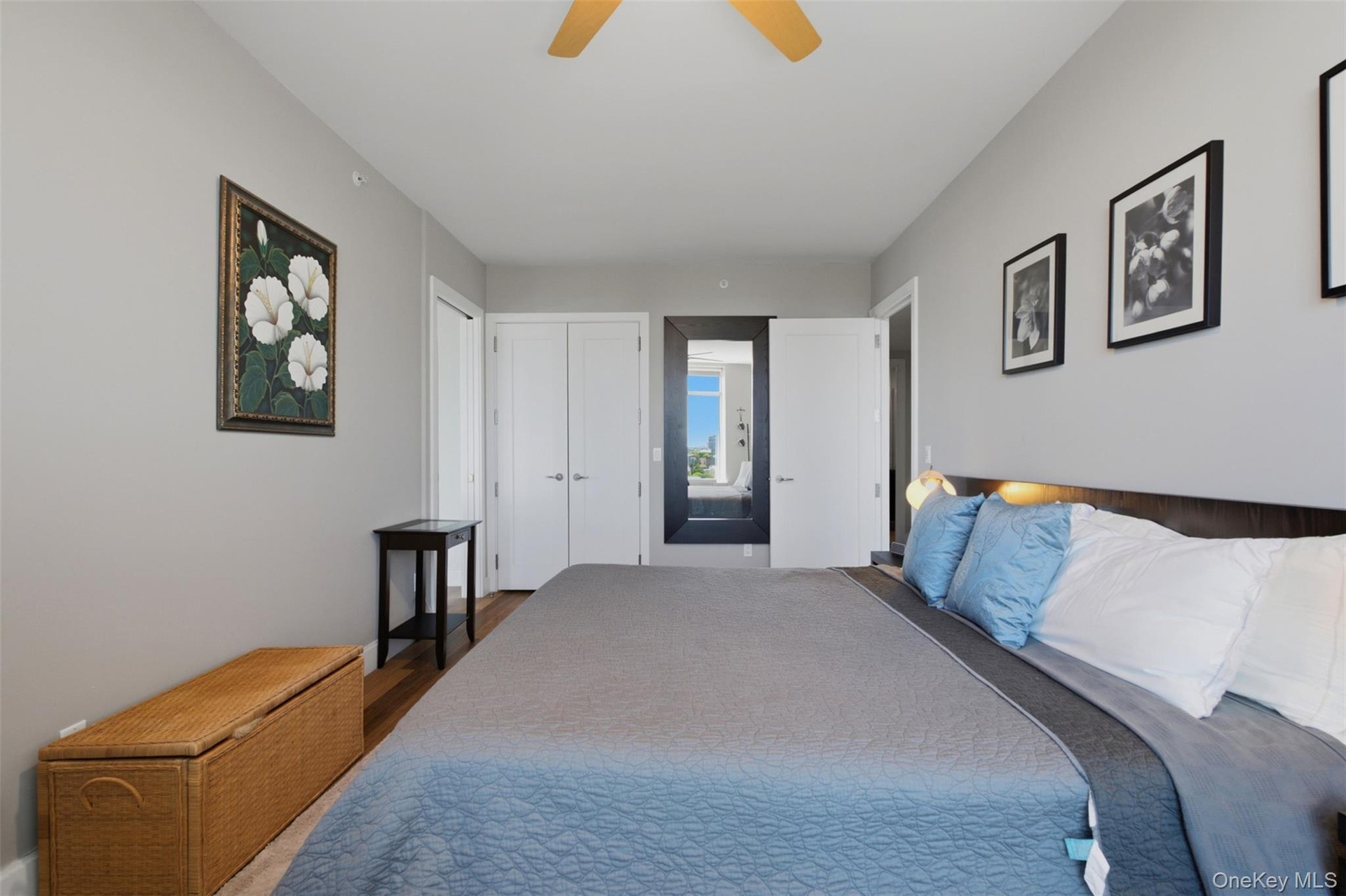 Bedroom 2 with light gray walls complement the wood-finish flooring in this room