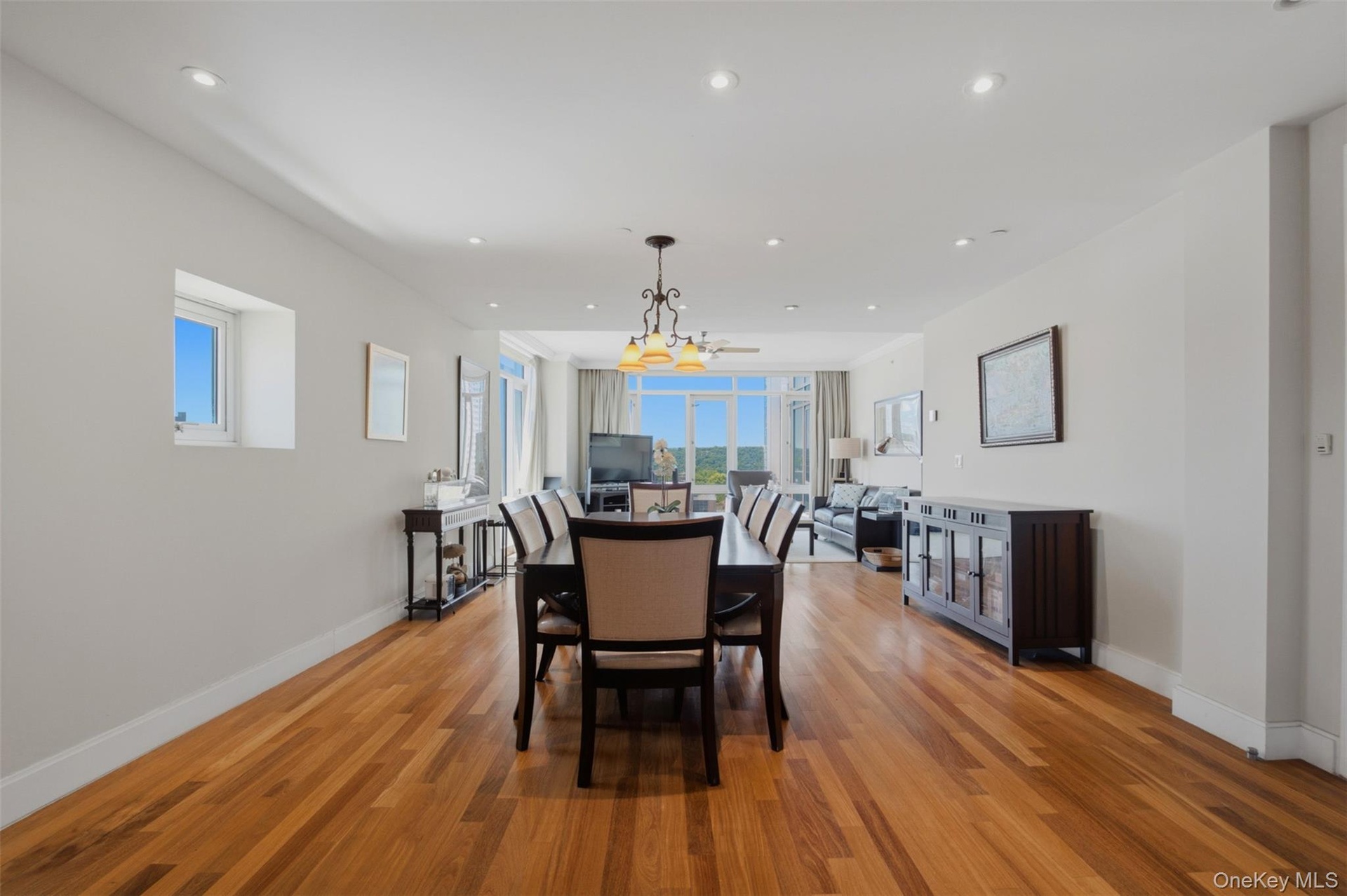 Open-concept living area featuring wood-finish flooring, recessed lighting, and expansive windows