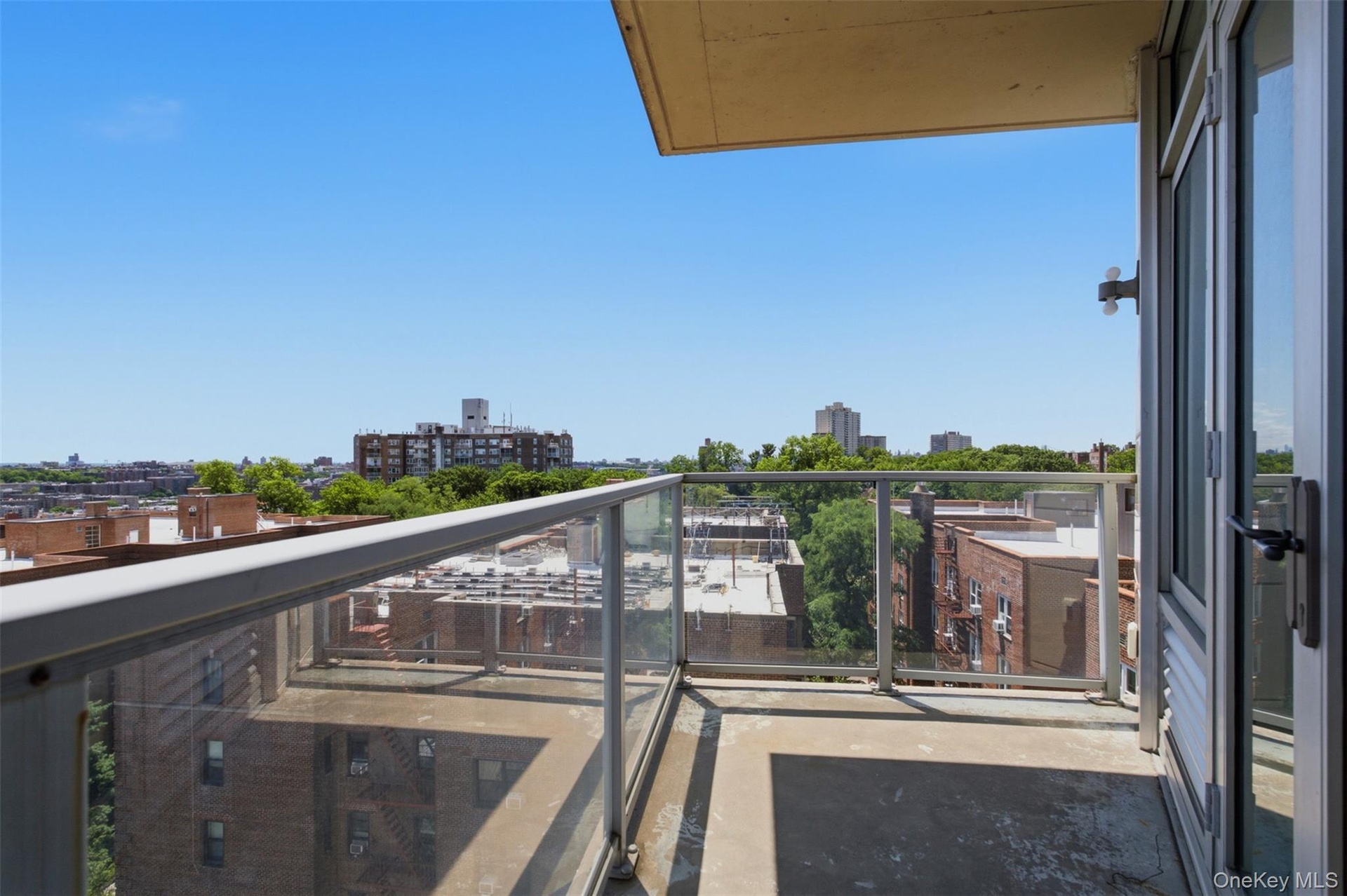 Private balcony with a concrete floor, glass railing, and aluminum frame