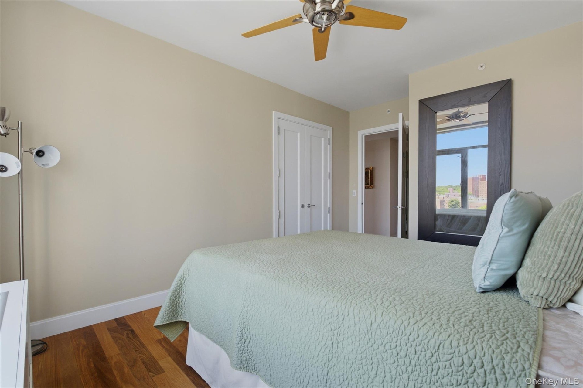 Bedroom 3. Light-filled room featuring wood-finish flooring, a ceiling fan, and white baseboards