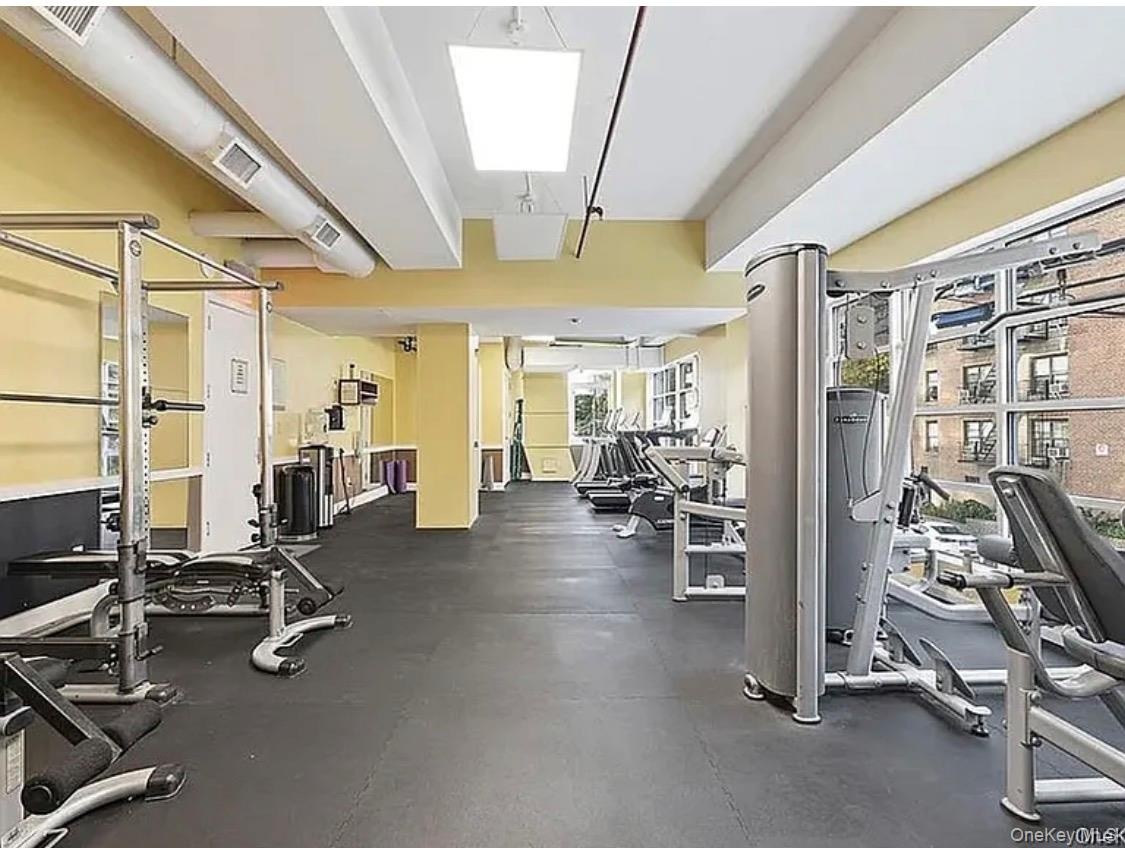 Expansive fitness center featuring commercial-grade equipment, rubberized flooring, and large windows
