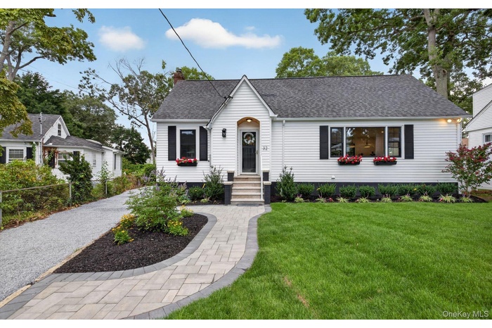 Charming white siding residence featuring a dark shingle roof and black window shutters