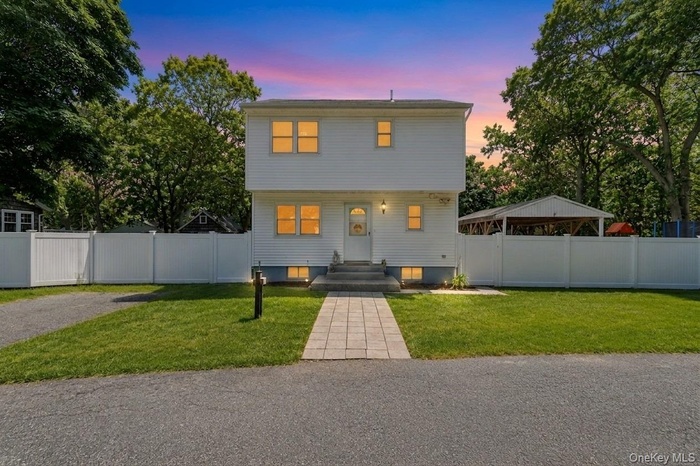White clapboard exterior with an arched entry door