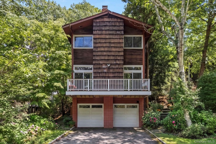 Split-level exterior featuring wood siding, balcony, and shake accents