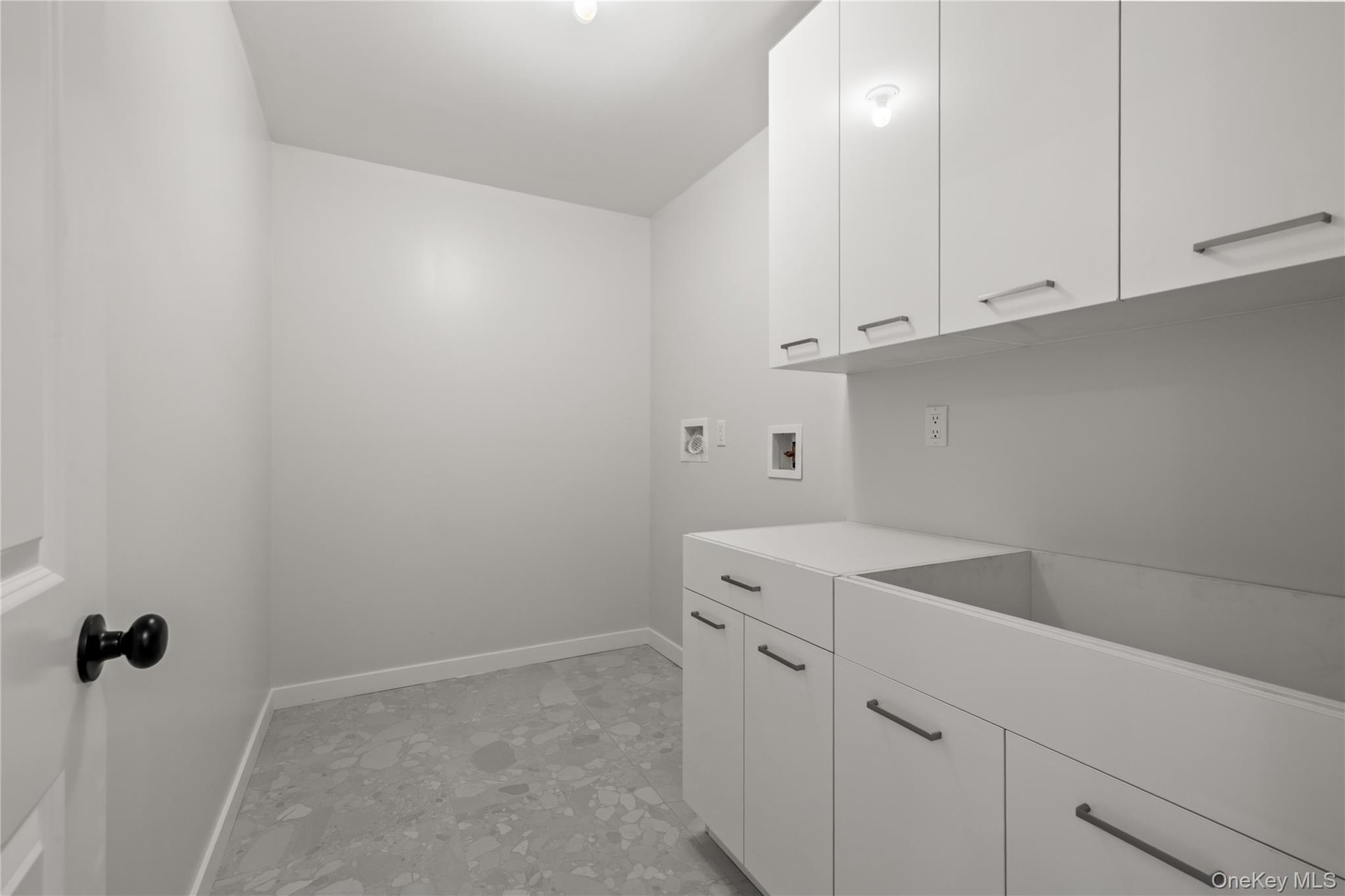 Well-organized laundry room with extensive white cabinets.
