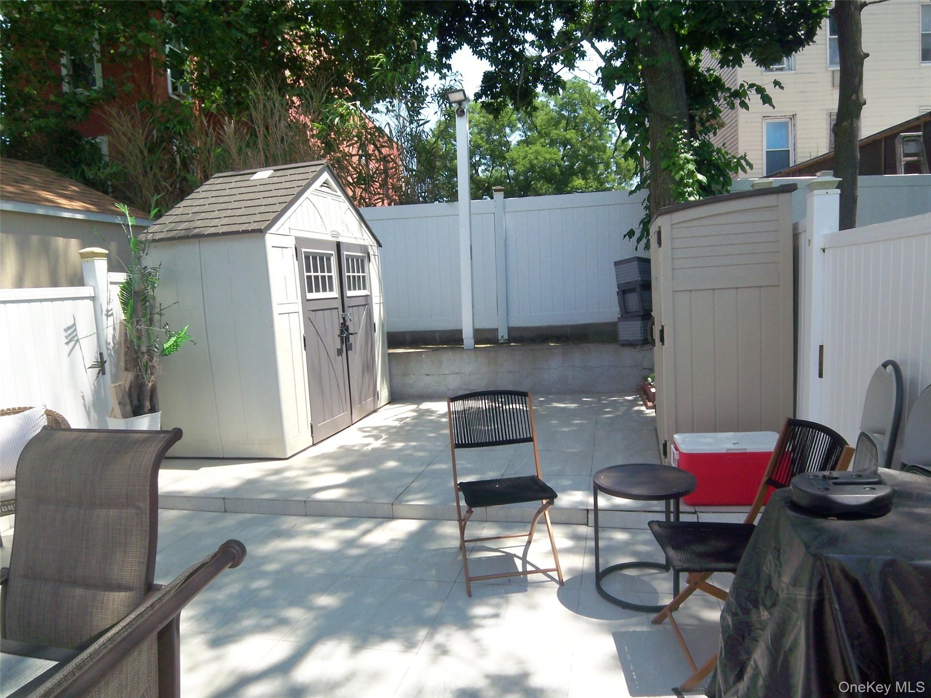 Paved patio area featuring two storage sheds