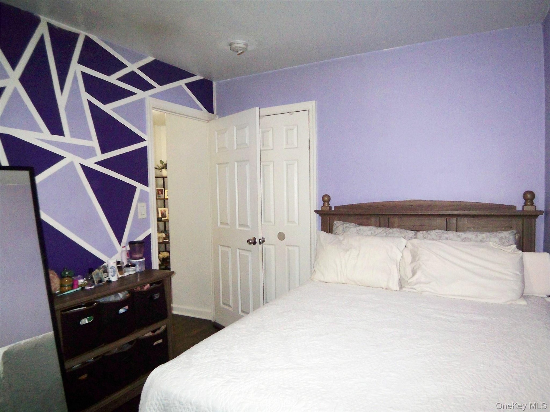 Room featuring a geometric accent wall in shades of purple