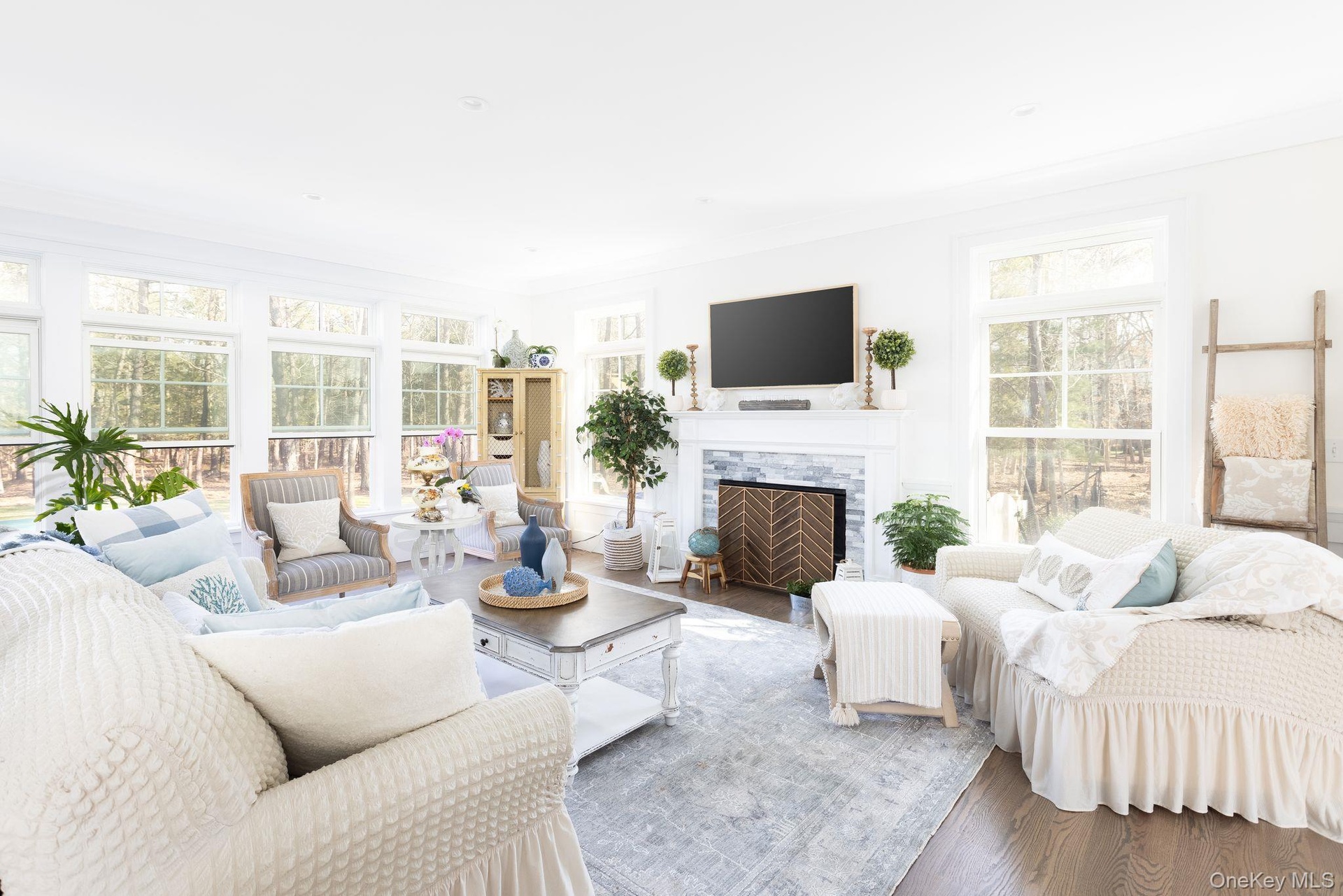 Living area featuring plenty of natural light, wood finished floors, and ornamental molding