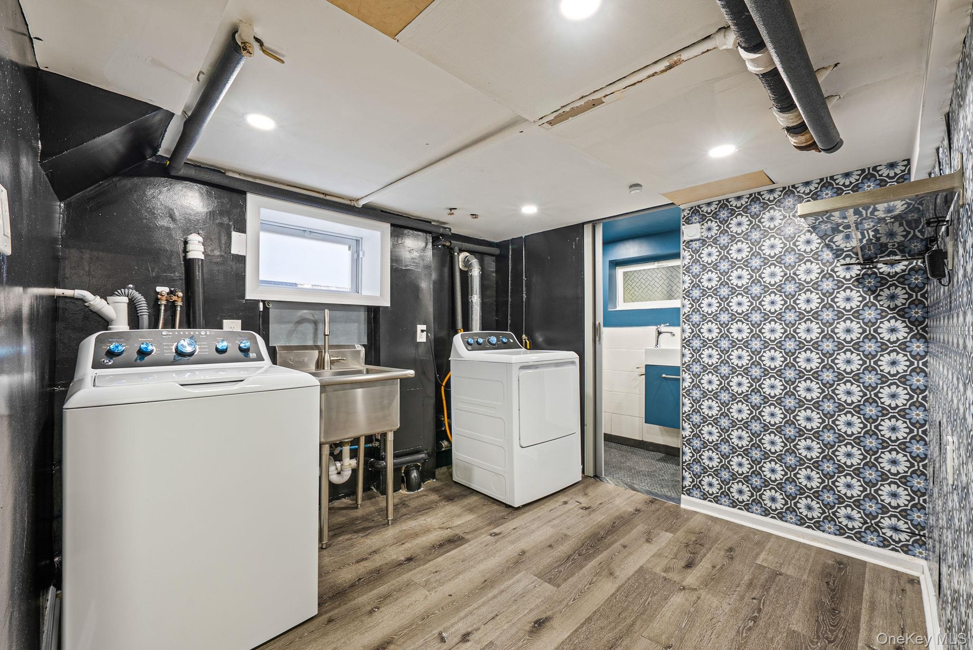 Laundry area featuring light wood-style floors and washing machine and dryer