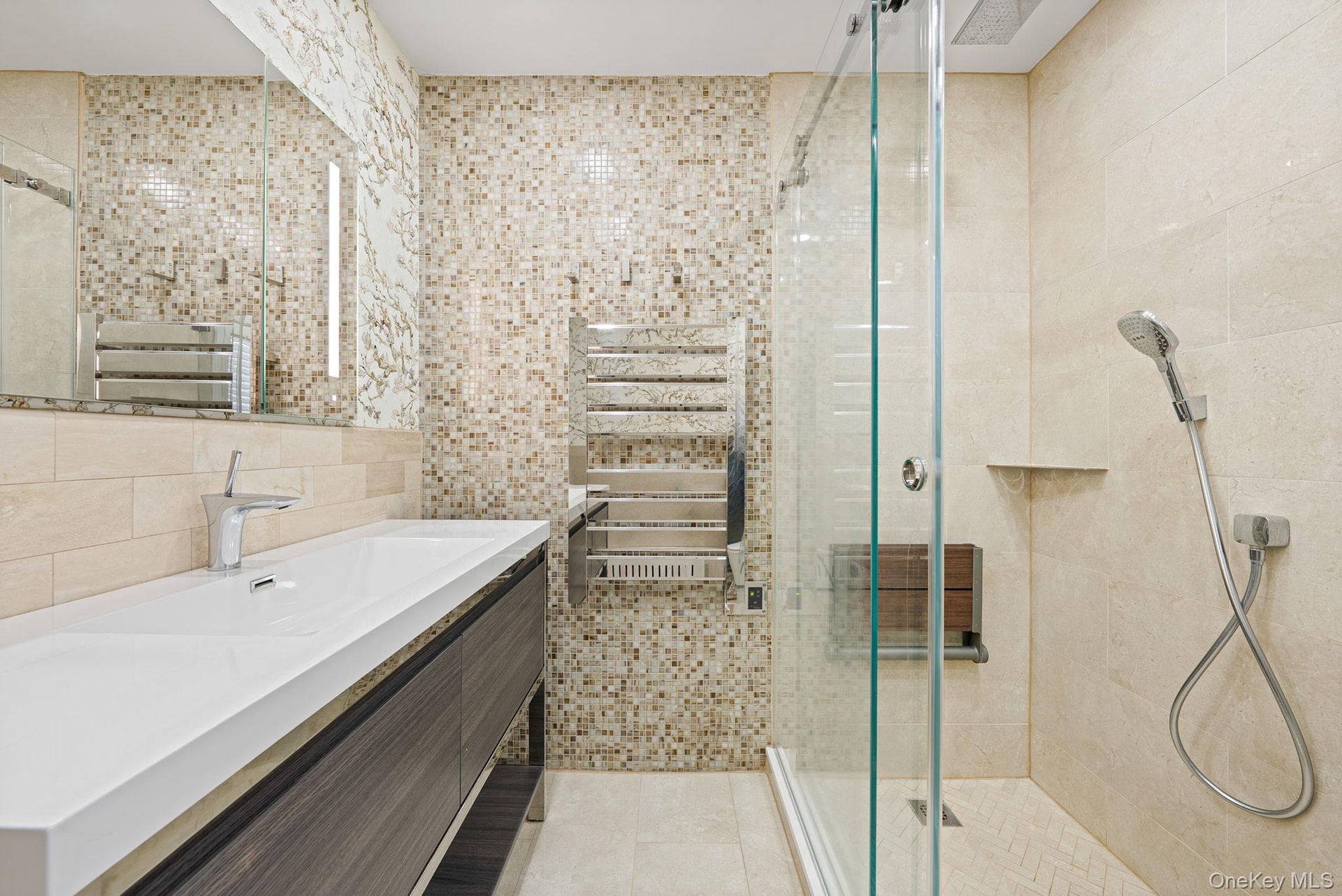 Full bathroom with a stall shower, vanity, tile walls, a towel warmer, and light tile patterned flooring
