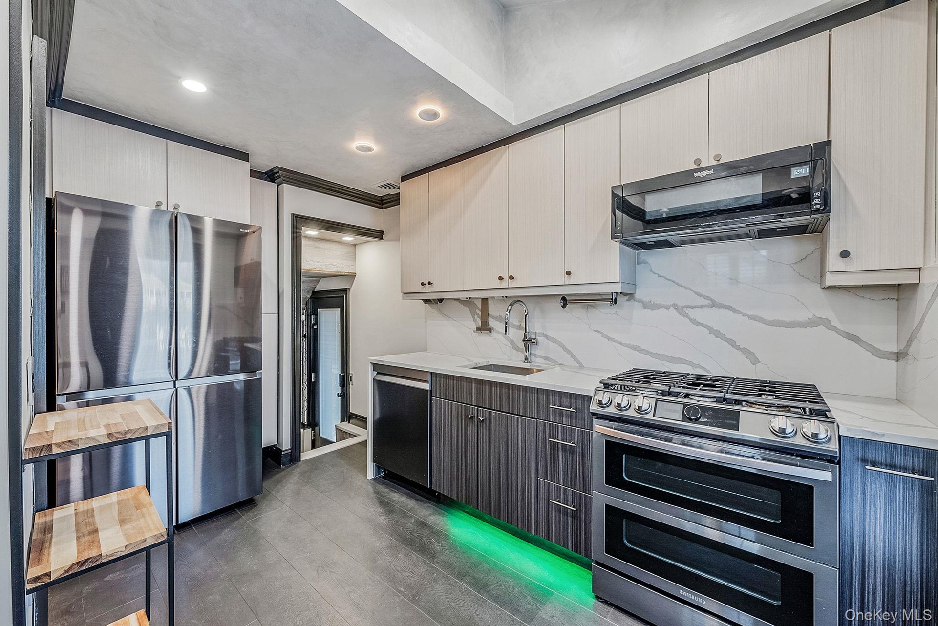 Kitchen featuring stainless steel appliances, ventilation hood, tasteful backsplash, light stone countertops, and recessed lighting