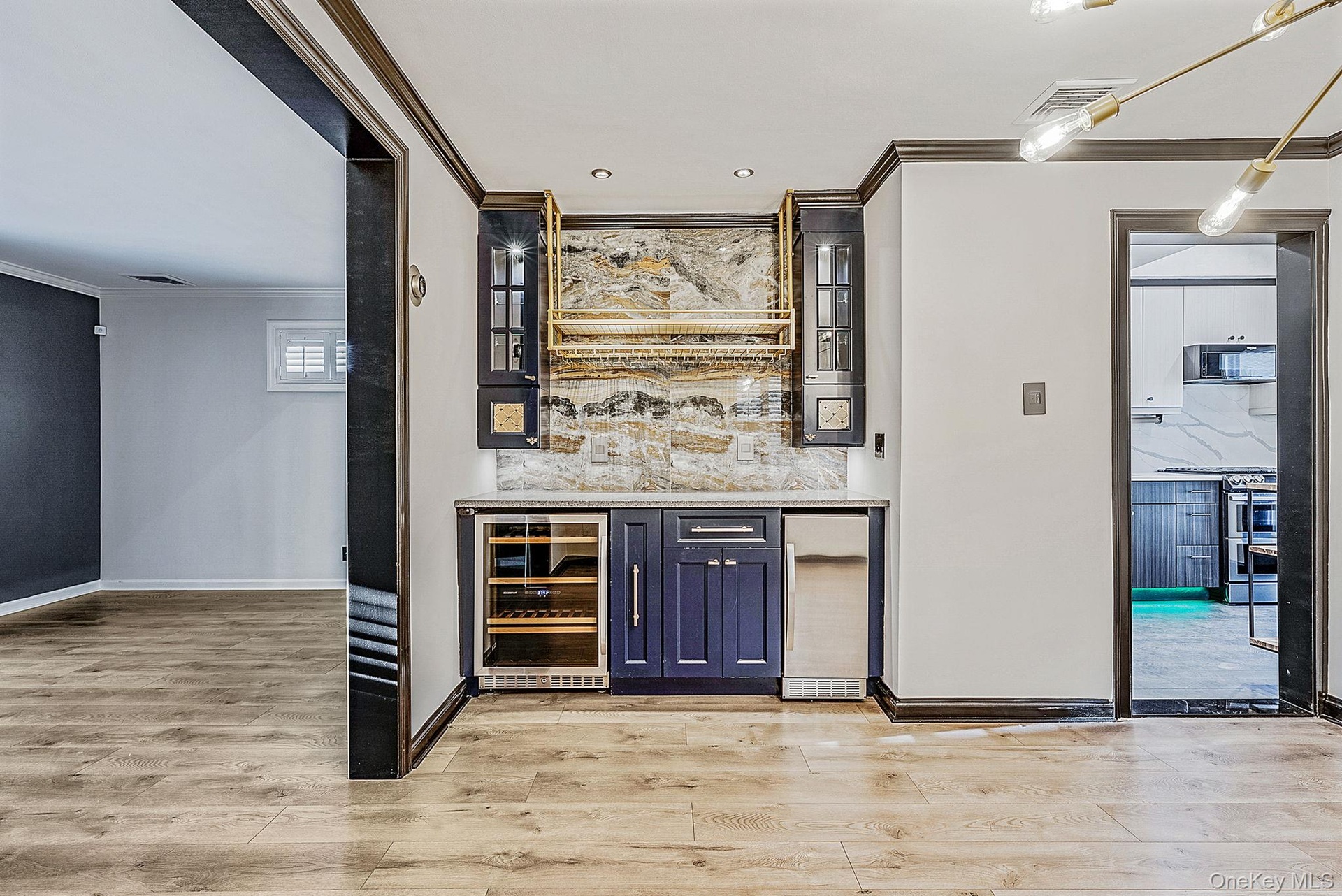 Indoor dry bar with glass insert cabinets, crown molding, wine cooler, light stone counters, and stainless steel range