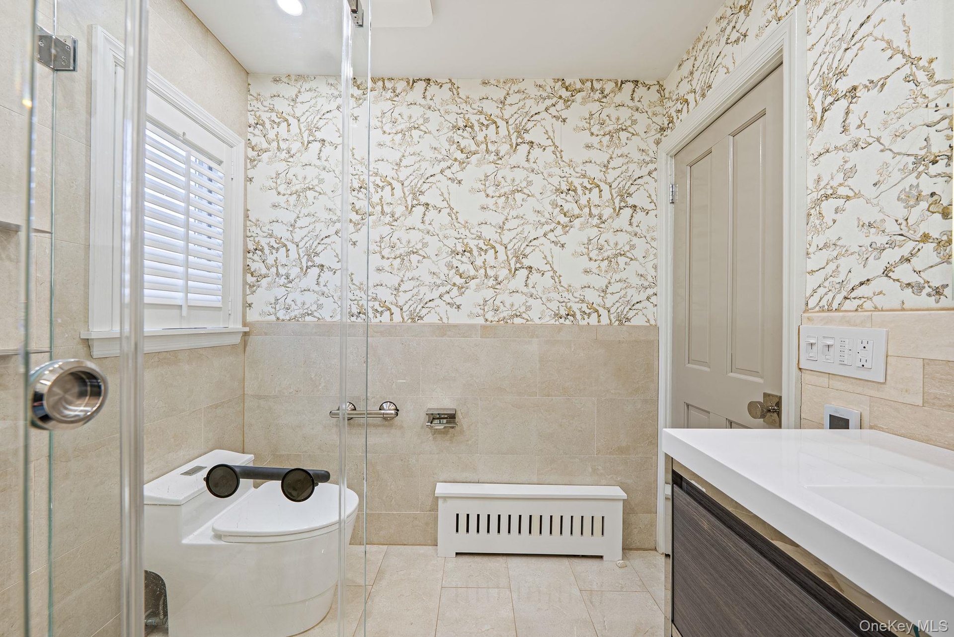 Full bathroom featuring a wainscoted wall, radiator, tile walls, vanity, and wallpapered walls