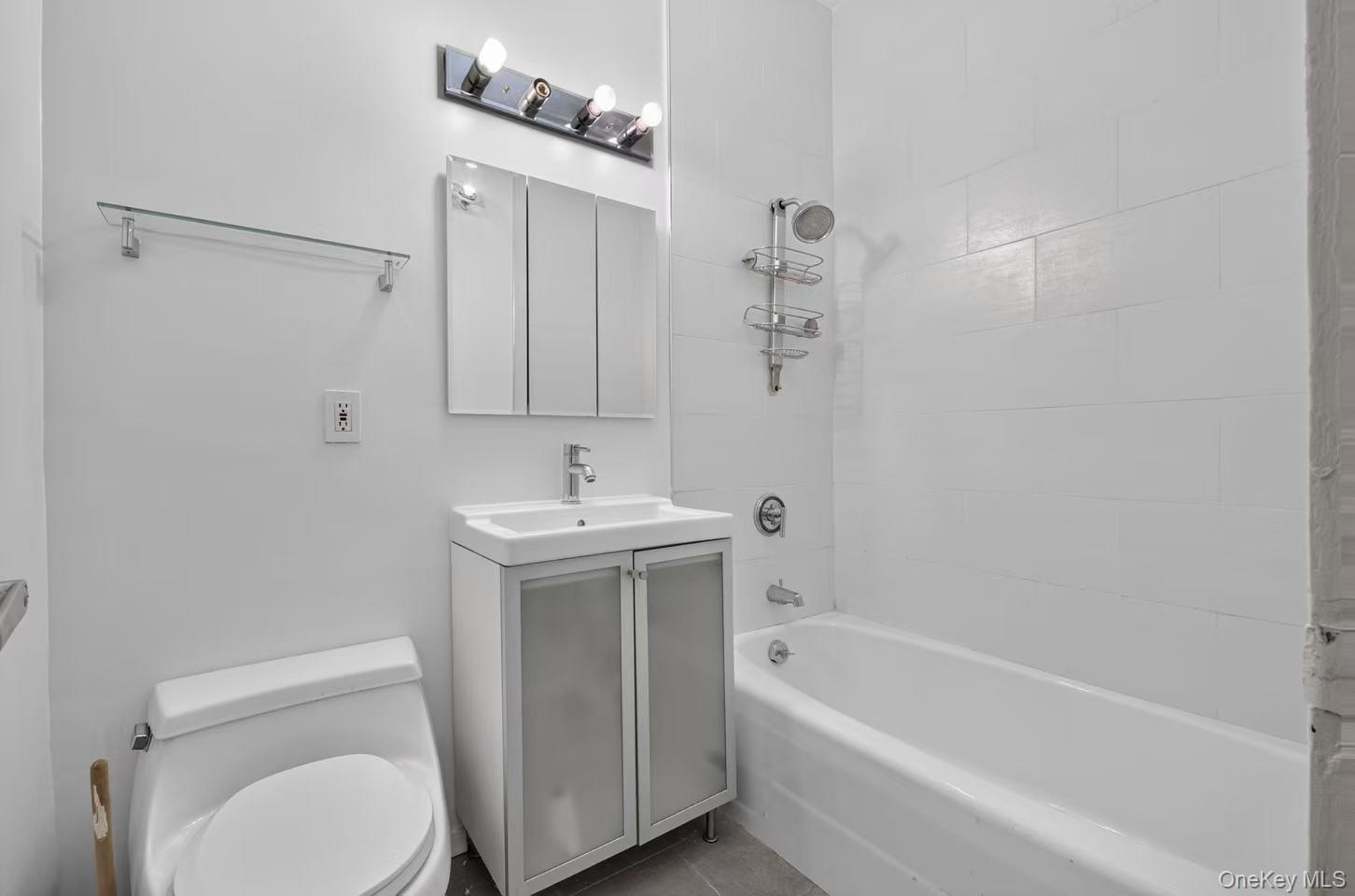 Modern bathroom featuring a white porcelain toilet, a vanity with a white basin and chrome faucet, and a medicine cabinet with mirrored doors