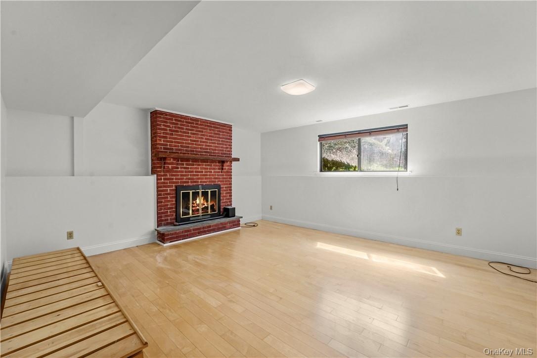 Lower level family room with traditional wood burning fireplace.