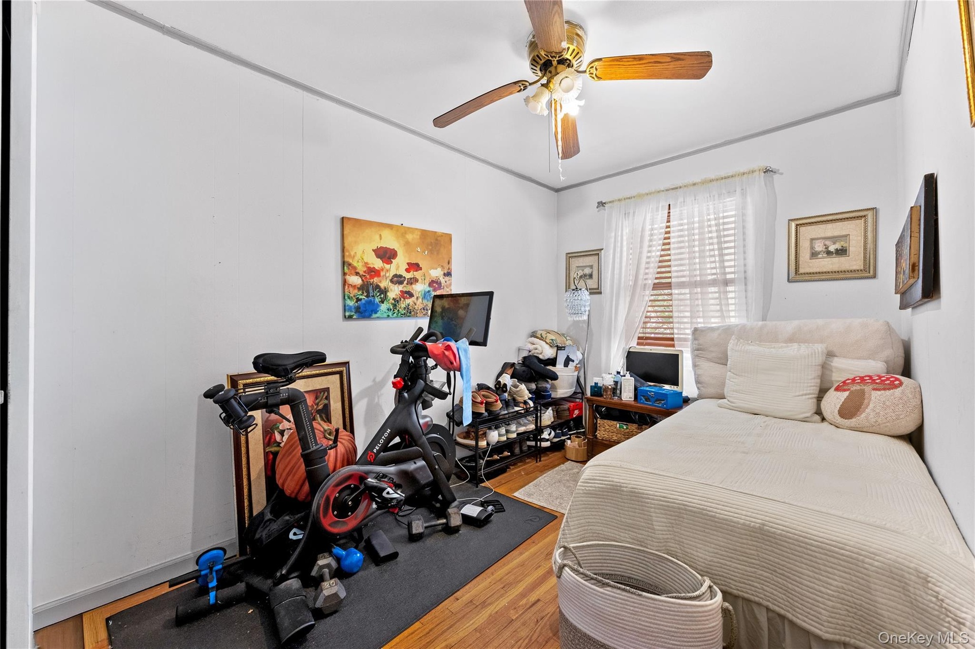 Bedroom 2 - Featuring wood-finish flooring, white walls, and a ceiling fan with integrated lighting