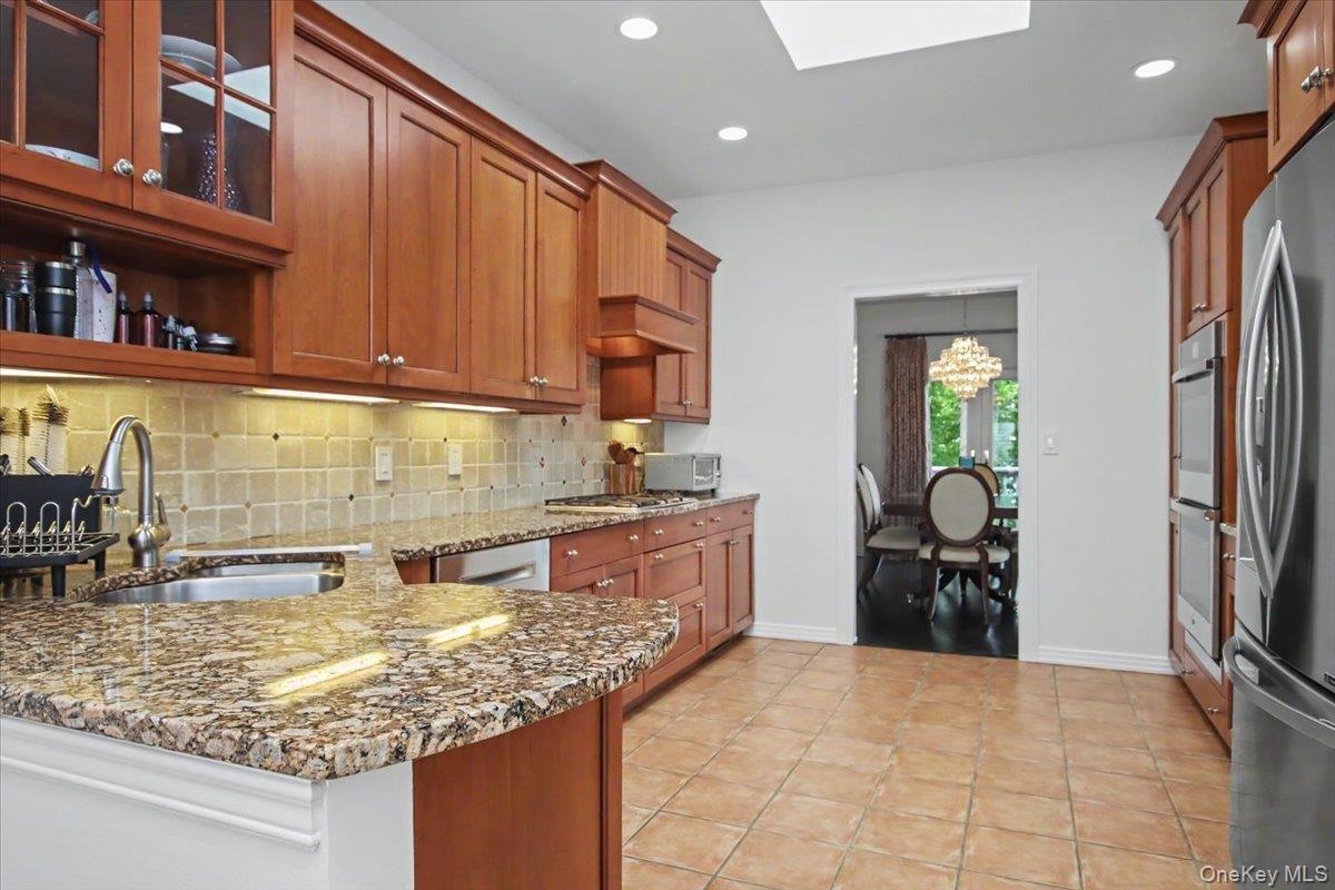Granite counters, wood cabinets, ceramic tiled floor.