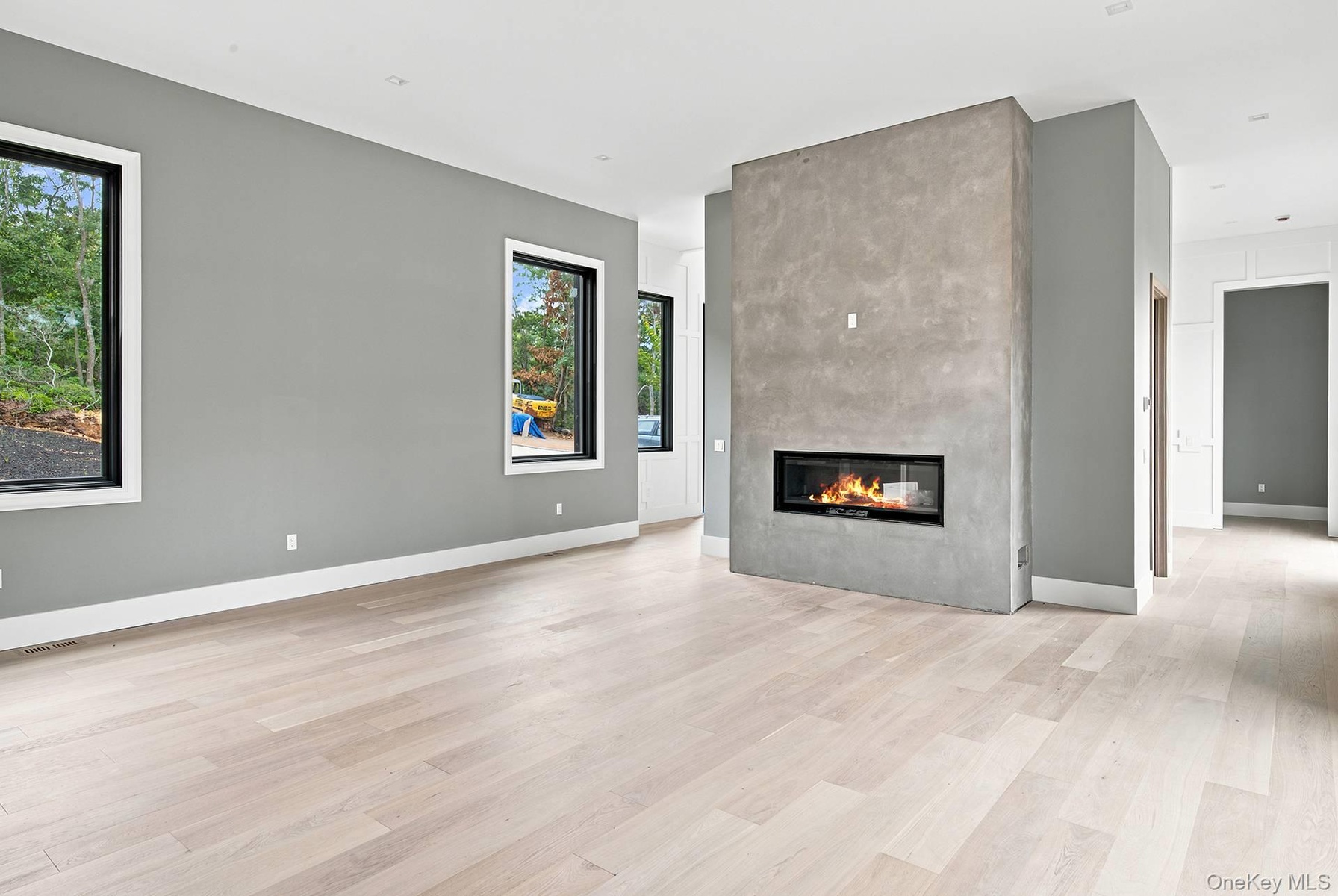 Spacious interior featuring a contemporary linear fireplace set within a textured accent wall