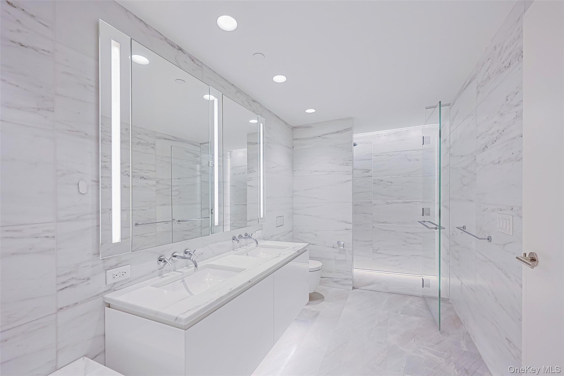 Primary Bathroom Spa-inspired bathrooms feature Blue de Savoie stone floors, Calacatta Lincoln marble walls, oversized walk-in showers, and meticulous