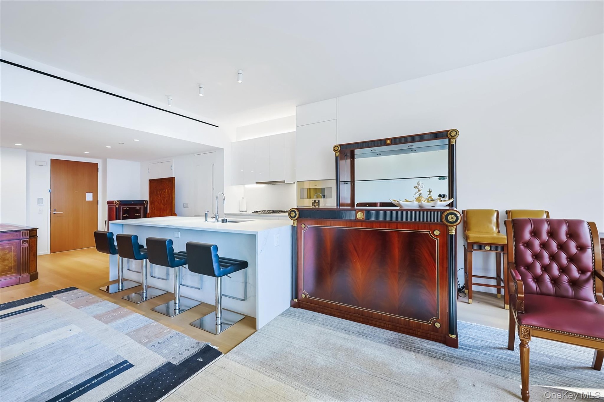 Breakfast Bar Featuring custom Italian white lacquer cabinetry, Calacatta Lincoln marble countertops, natural stone finishes with waterfall edges