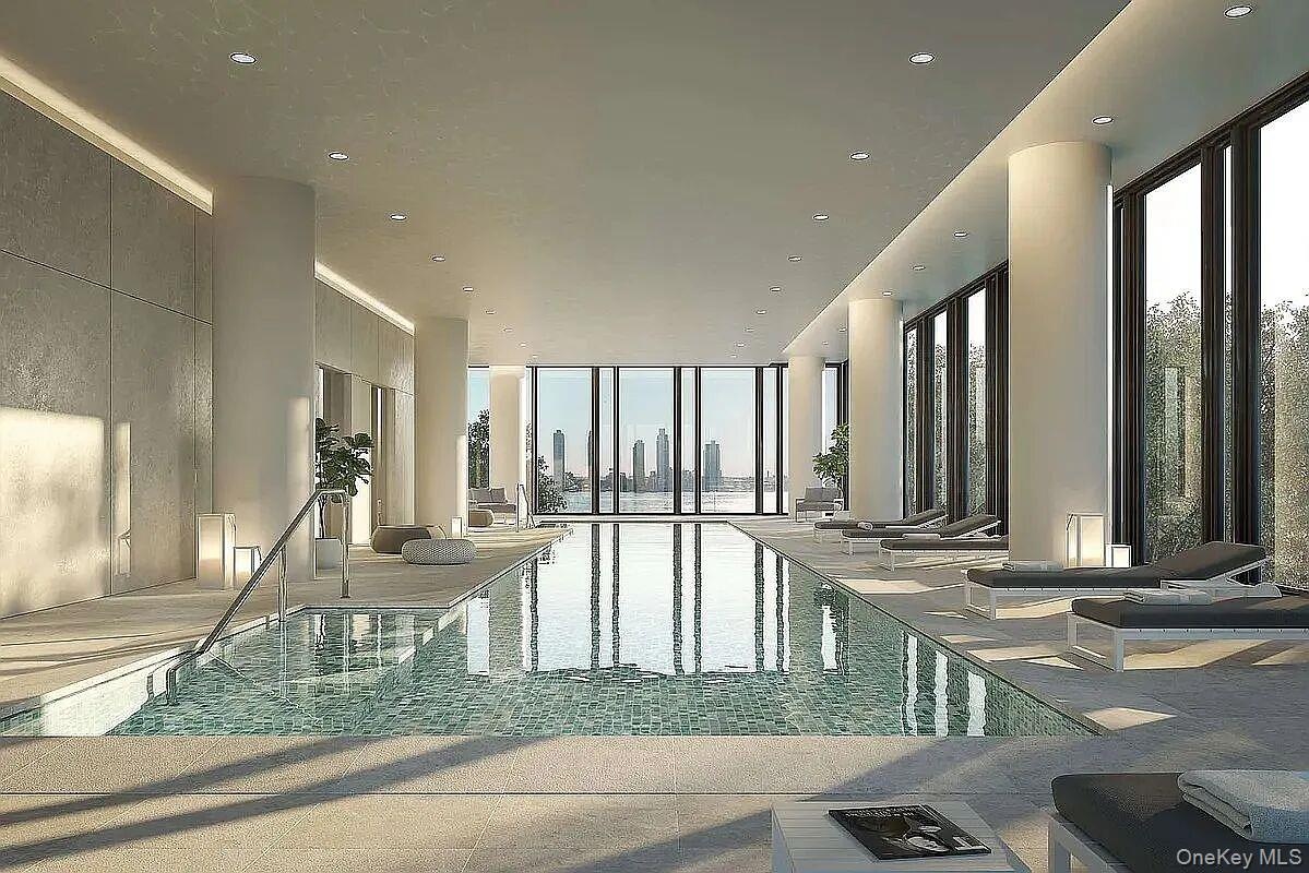 Indoor swimming pool featuring floor-to-ceiling windows, recessed lighting, tile flooring, and a cityscape backdrop