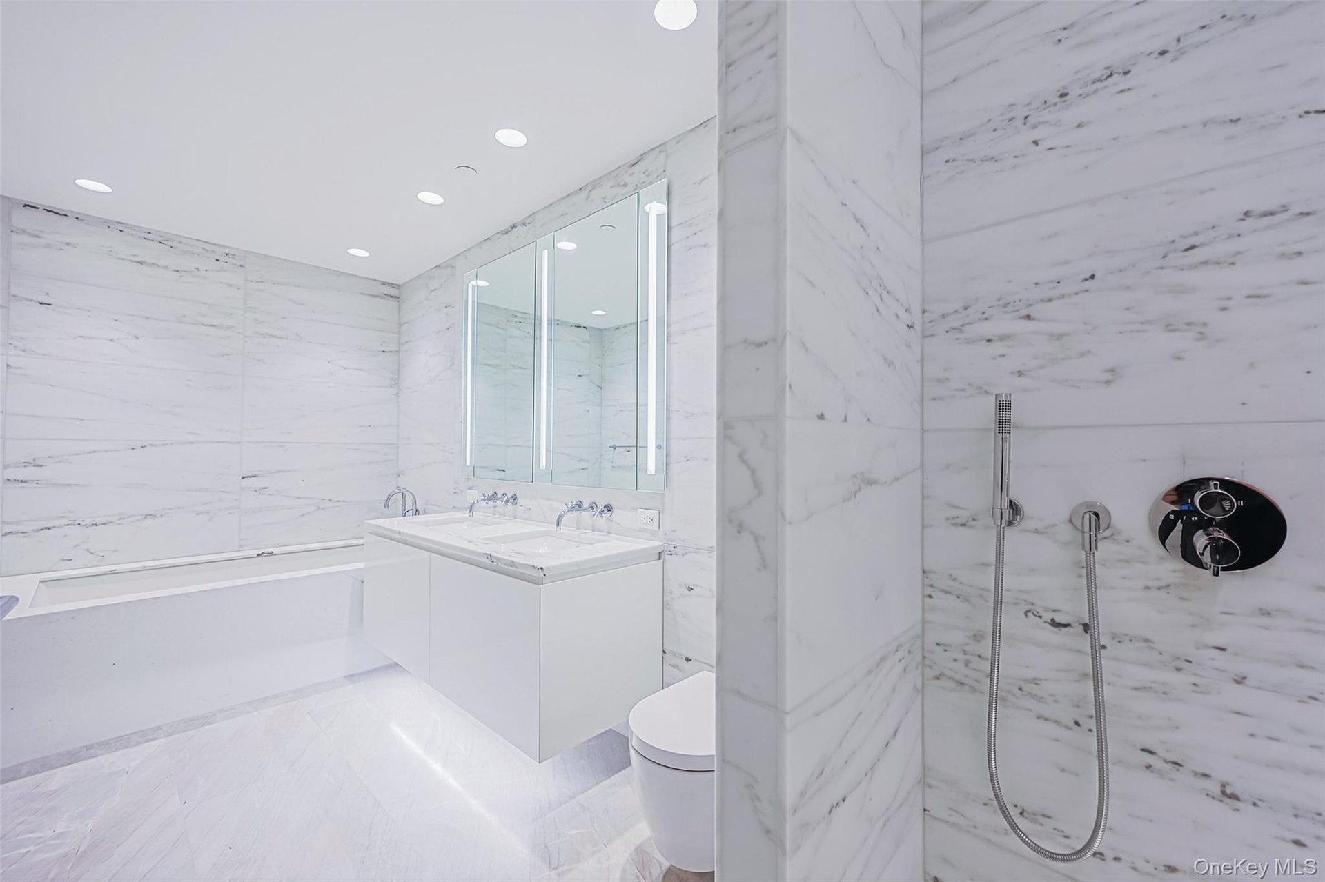 Primary Bathroom Spa-inspired bathrooms feature Blue de Savoie stone floors, Calacatta Lincoln marble walls, oversized walk-in showers, and meticulous