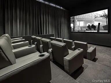 Dedicated theater featuring tiered seating, individual recliners with cupholders, a large projection screen located in Common Area on 2nd Floor