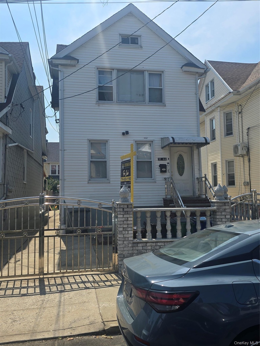 Two-story exterior featuring white siding and a gabled roofline